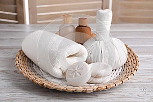 Spa composition with skin care products and wicker basket on white wooden table