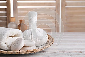 Spa composition with skin care products and wicker basket on white wooden table, space for text