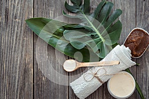 Spa composition with towels and tropical leaf on a wooden background