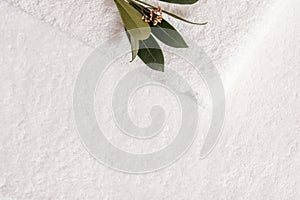 Spa composition on wooden table. Stack of three white fluffy bath towels with eucalyptus branch. Copy space