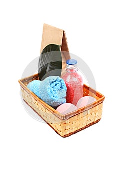 Spa concept with bottle of pink bath salt a blue towel, paper bag and two pink salt balls