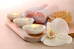 Spa concept with burning aromatic candles and white orchid