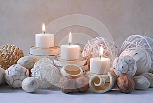 Spa concept of burning white candles decorated with natural dried potpourri