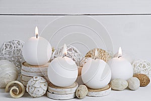 Spa concept of burning white candles decorated with natural dried potpourri