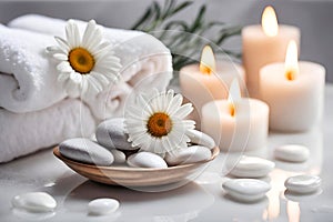 Spa concept, massage stones with towels, candles and daisy flowers.