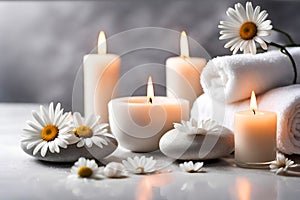 Spa concept, massage stones with towels, candles and daisy flowers.