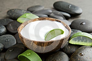 Spa concept. slice aloe vera on white cream in coconut shell wit