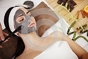 Spa concept. Young woman with nutrient facial mask in beauty sal