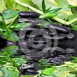 Spa-concept with zen stones and bamboo reflected in a water