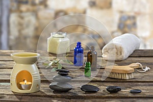 Spa concept: zen stones, candles and flowers against old stone wall on the background