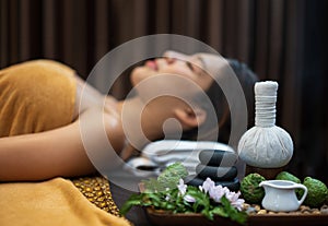 Spa concept, Zen stones, Candles and flowers on the background of woman receiving treatment, Young beautiful woman in spa