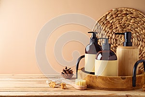 SPA cosmetics bottles with labels for mock up packaging design on wooden table over beige background. Natural beauty products