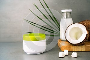 Spa cream for body skincare and hair with coconut oil, fresh coconuts, palm leaf and bottle with coconut butter on dark
