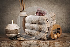 Spa essentials, aroma sticks, stones, towels, sea shell on a wooden rustic background