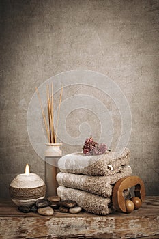 Spa essentials, aroma sticks, stones, towels, sea shell on a wooden rustic background