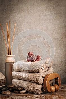 Spa essentials, aroma sticks, stones, towels, sea shell on a wooden rustic background