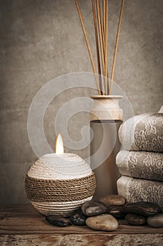 Spa essentials, aroma sticks, stones, towels, sea shell on a wooden rustic background