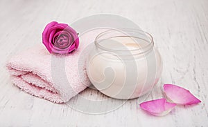 Spa essentials cream with towels and rose