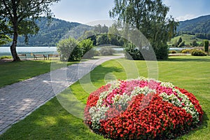 Spa garden schliersee at springtime, walkway in the park, blooming begonias in a flower bed