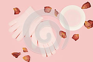 Spa gel moisturizing gloves and rose petal isolated on pink background. Skin care concept