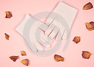 Spa gel moisturizing gloves and rose petal on pink background. skin care concept