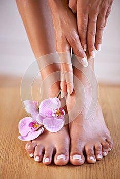 Spa girl and flower feet with hands on skin for luxury cosmetic treatment with manicure and pedicure nails. Healthy