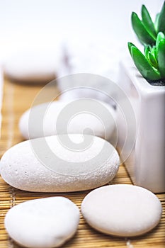 Spa, heath and beauty concept - massage stones,towel with flower