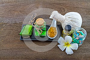Spa herbal white frangipani flowers, pill,Aloe vera essential oil and gel,compressing ball turmeric powder on wooden background