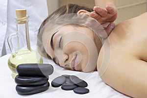 Spa Hot Stone Massage. Stone treatment. Woman getting a hot stone massage at a day spa