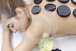 Spa Hot Stone Massage. Stone treatment. Woman getting a hot stone massage at a day spa