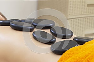 Spa Hot Stone Massage. Stone treatment. Woman getting a hot stone massage at a day spa.