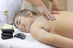 Spa Hot Stone Massage. Stone treatment. Woman getting a hot stone massage at a day spa.