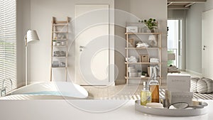 Spa, hotel bathroom concept. White table top or shelf with bathing accessories, toiletries, over blurred luxury contemporary cosy