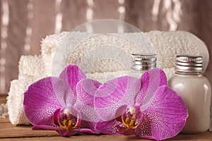 Spa kit with lotions for skin, orchid flowers and white towels