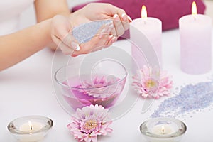 Spa Manicure. Woman Hands With Perfect Natural Healthy Nails Soaking In Aroma Hand Bath. Closeup Of Glass Bowl With Water And Blu