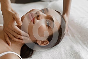 Spa Massage. Beautiful Woman Getting Facial Beauty Treatment