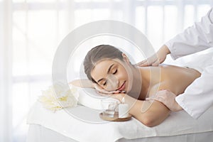 Spa Massage. Indian Woman Relaxing On Table While Therapist Massaging Her Shoulders