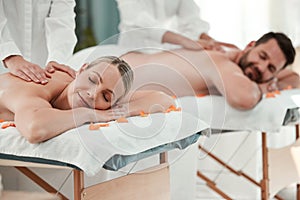 Spa, massage and relax with a couple on a bed for massaging, treatment or wellness in a health club. Luxury, beauty and