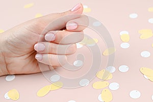 Spa and nanicure concept. Beautiful hand of a young girl with fresh pastel manicure on a pink background