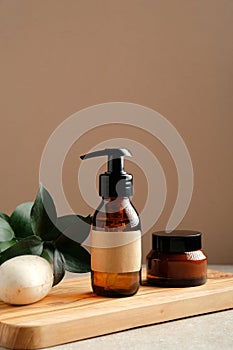 SPA natural organic cosmetics set on wooden board. Shower gel or shampoo amber glass dispenser bottle, jar of moisturizer cream,