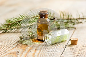 Spa with organic spruce oil and sea salt in glass bottles on wooden table background