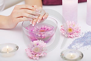 Spa Procedure. Woman In Beauty Salon Holding Fingers In Aroma Ba