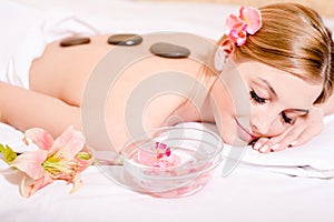 During spa procedures stone therapy massage blond pretty girl having fun eyes closed picture