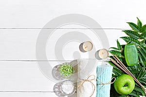 Spa products. Bath salts, soap, candles and towel. Flat lay on white wooden background, top view.