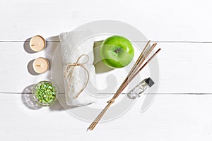 Spa products. Bath salts, soap, candles and towel. Flat lay on white wooden background, top view.