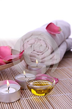 Spa products with rose petals, oil, towel