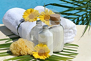 Spa products and towels by the pool