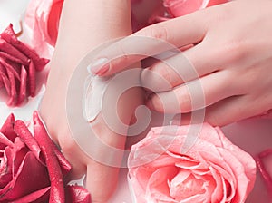 Spa Salon: Beautiful Female Hands with French Manicure in the Bowl of Water with Pink Roses and Rose Petals