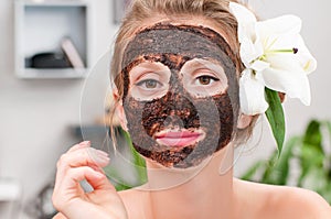 Spa salon. Beautiful woman with facial mask at beauty salon