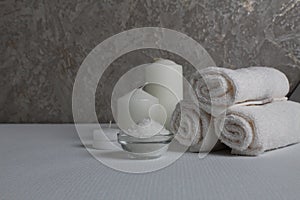 Spa salon, spa treatments. Towels, candles salt to wrap on a gray white background with a place for text and with a copyspace
